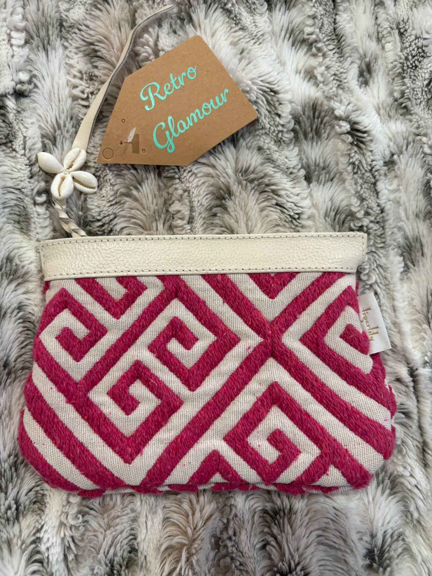 Pink and white patterned pouch on a textured surface