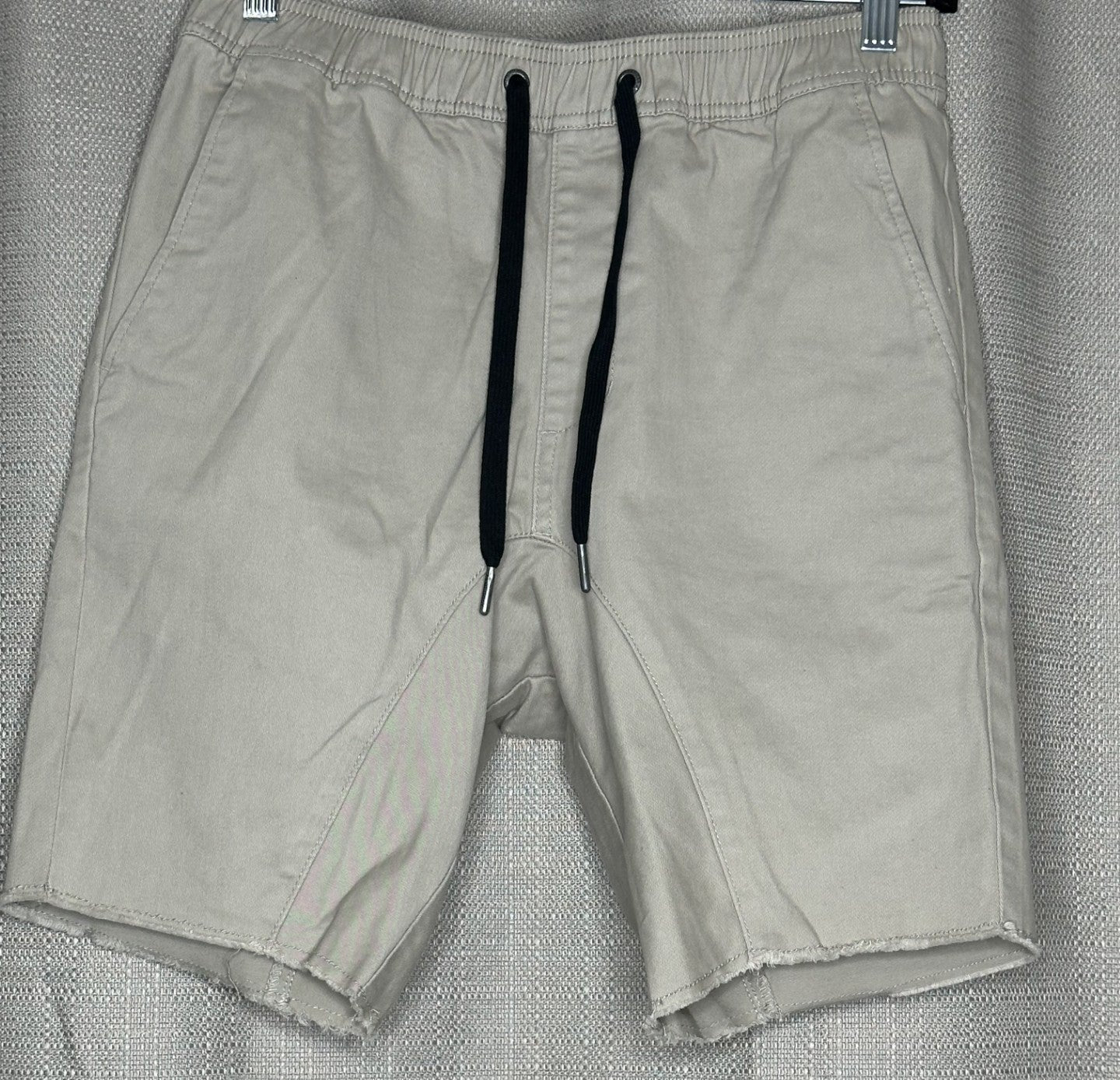 Light Beige shorts with black drawstring waist.