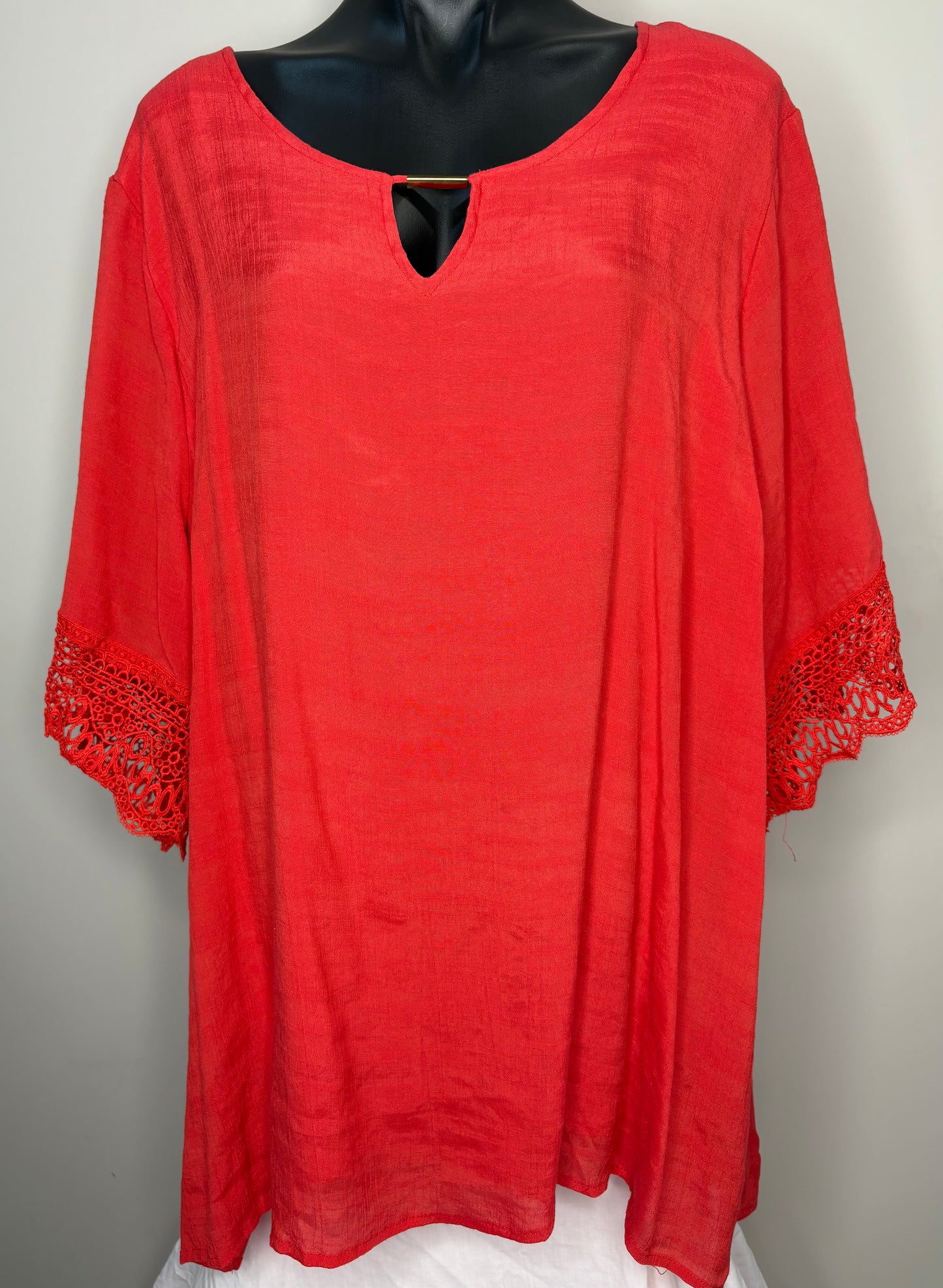 Red dress with lace trim on a mannequin against a gray background