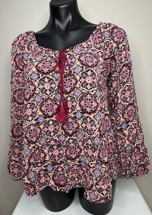 Patterned blouse on a mannequin against a neutral background
