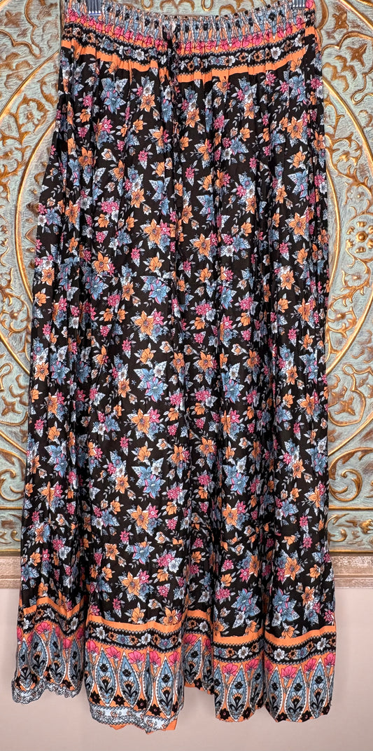 Floral patterned skirt with colorful border on a decorative wall background