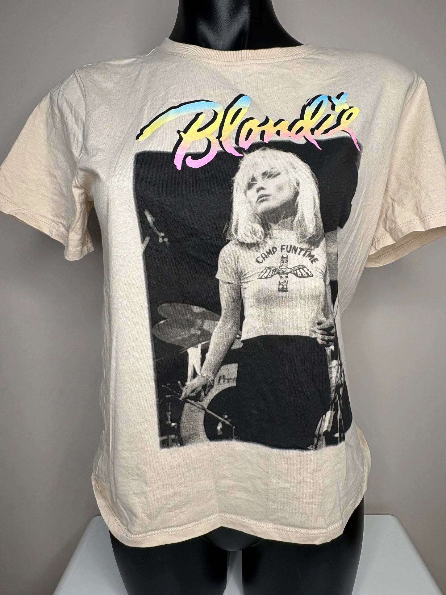 T-shirt with a graphic of a woman playing drums and the word 'Blondie' on a mannequin against a gray background.