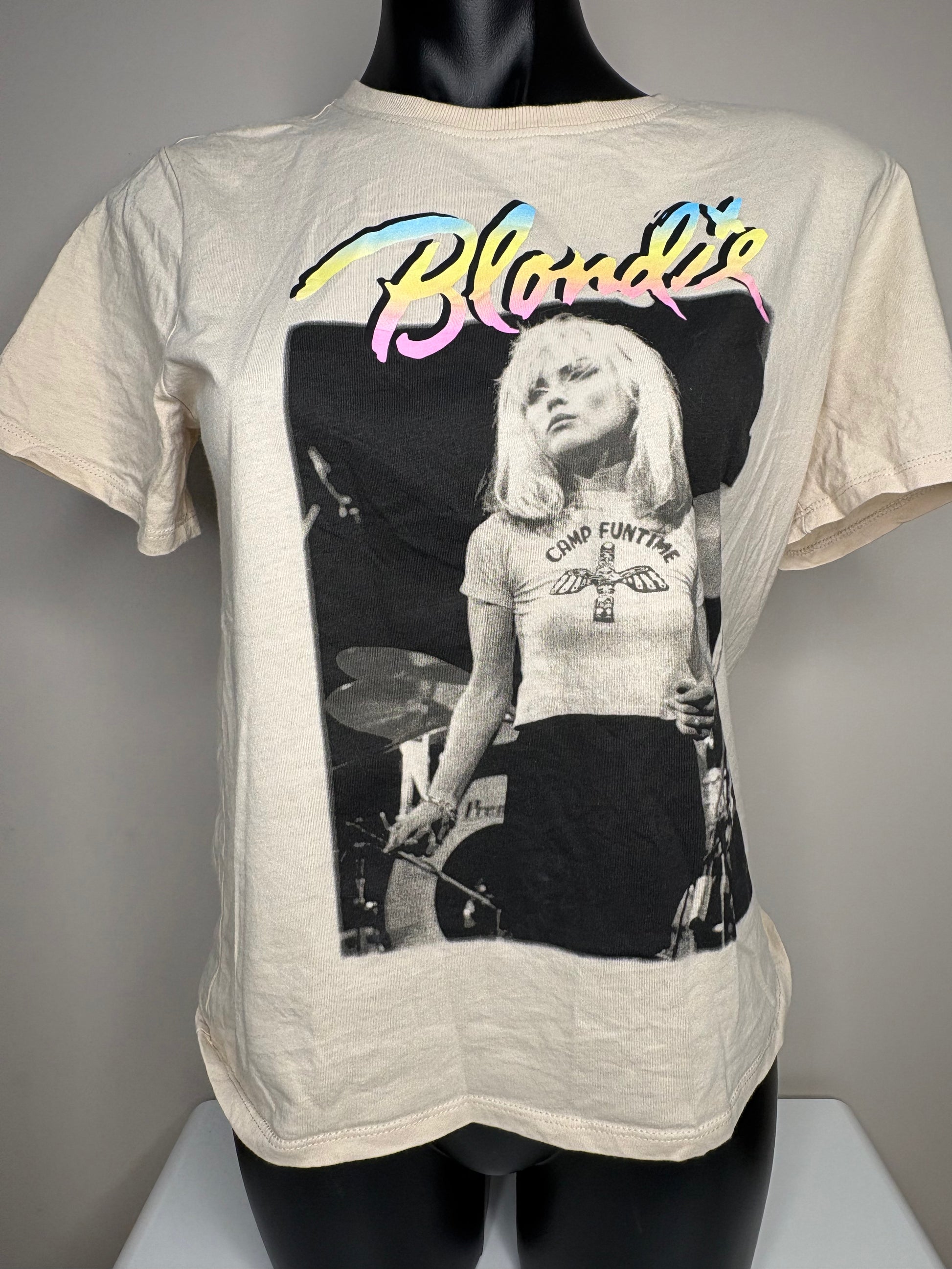 T-shirt with a graphic of a woman playing drums and the word 'Blondie' on a mannequin against a gray background.