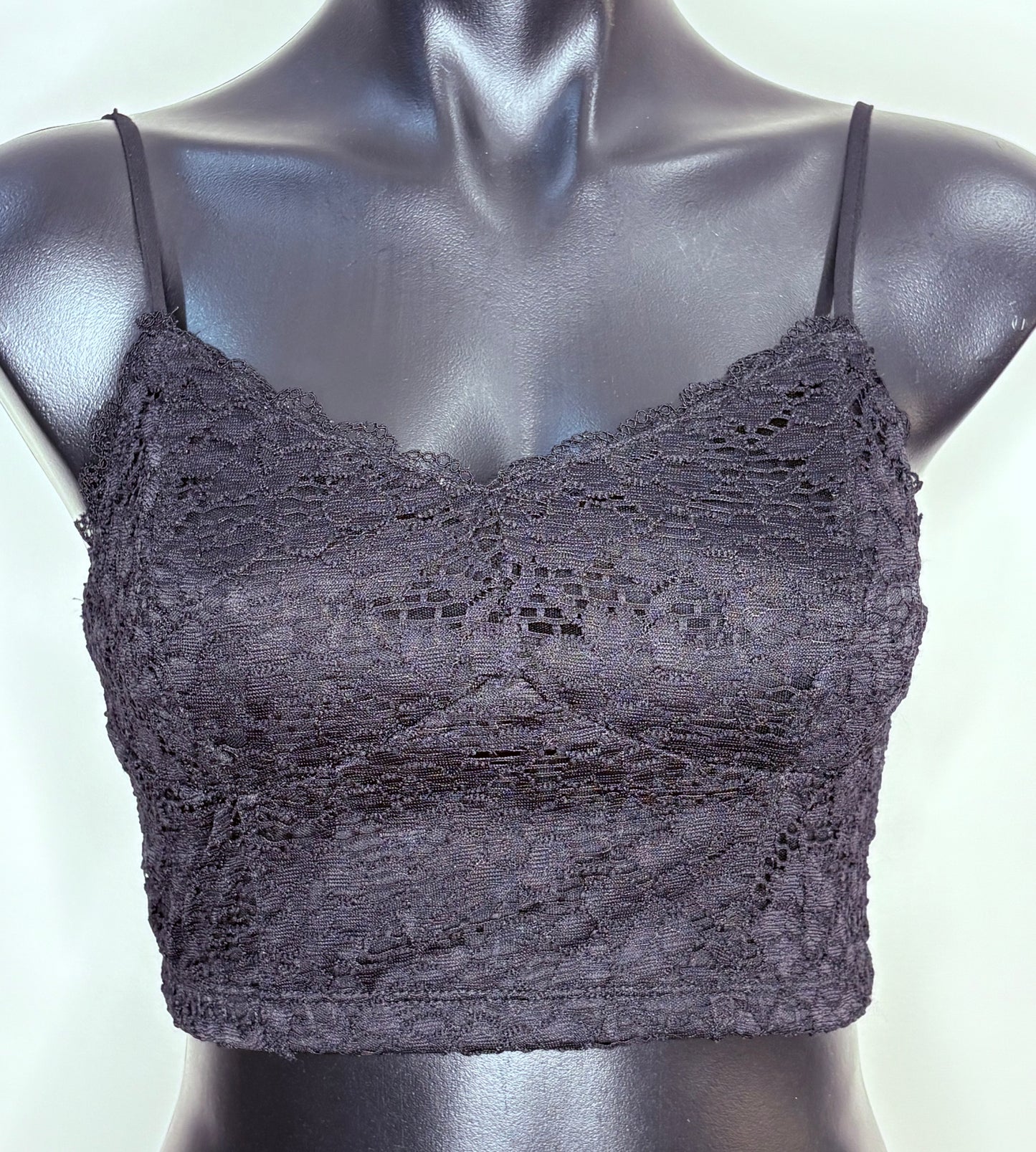 Black lace bralette on a mannequin against a white background
