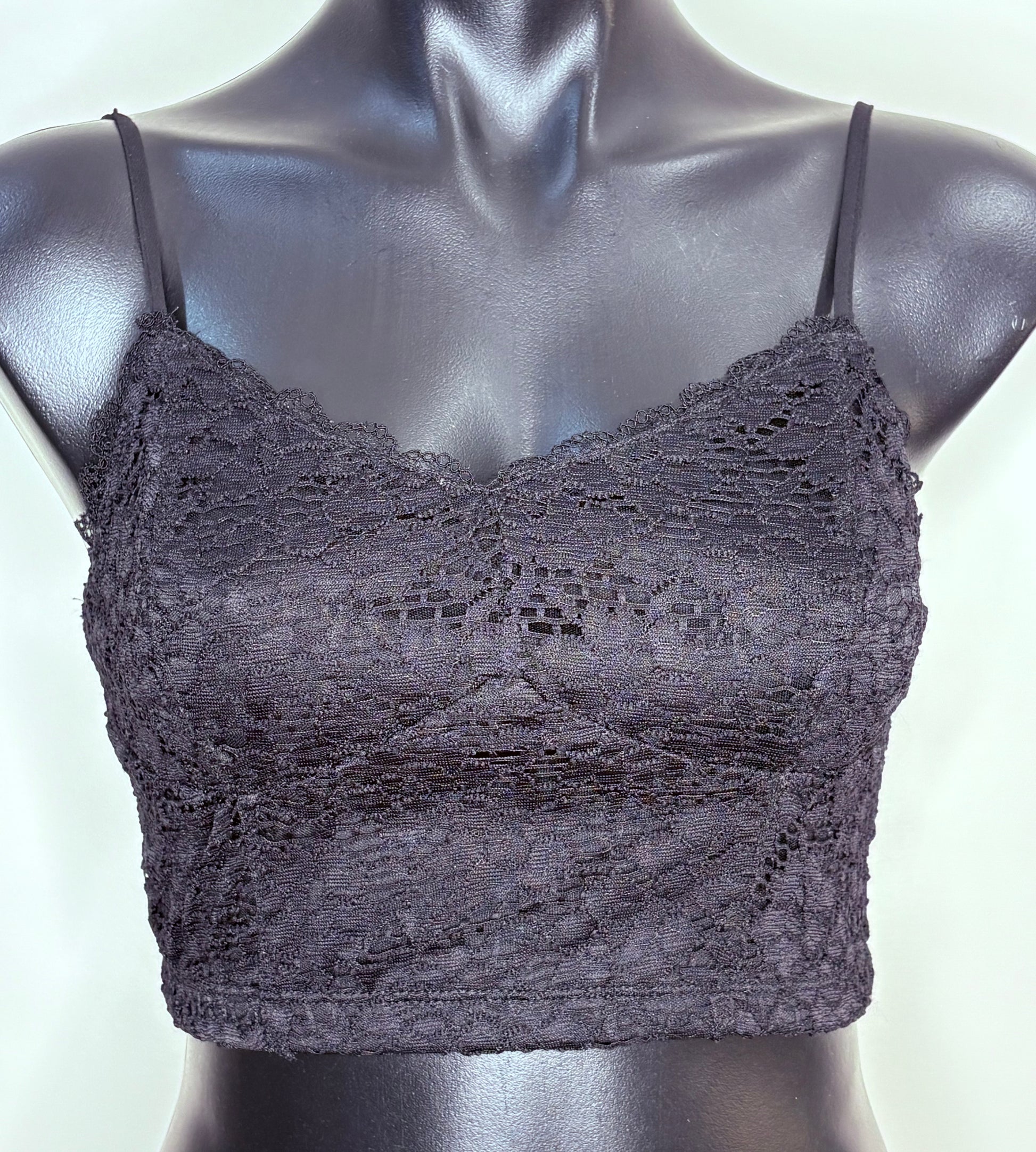Black lace bralette on a mannequin against a white background