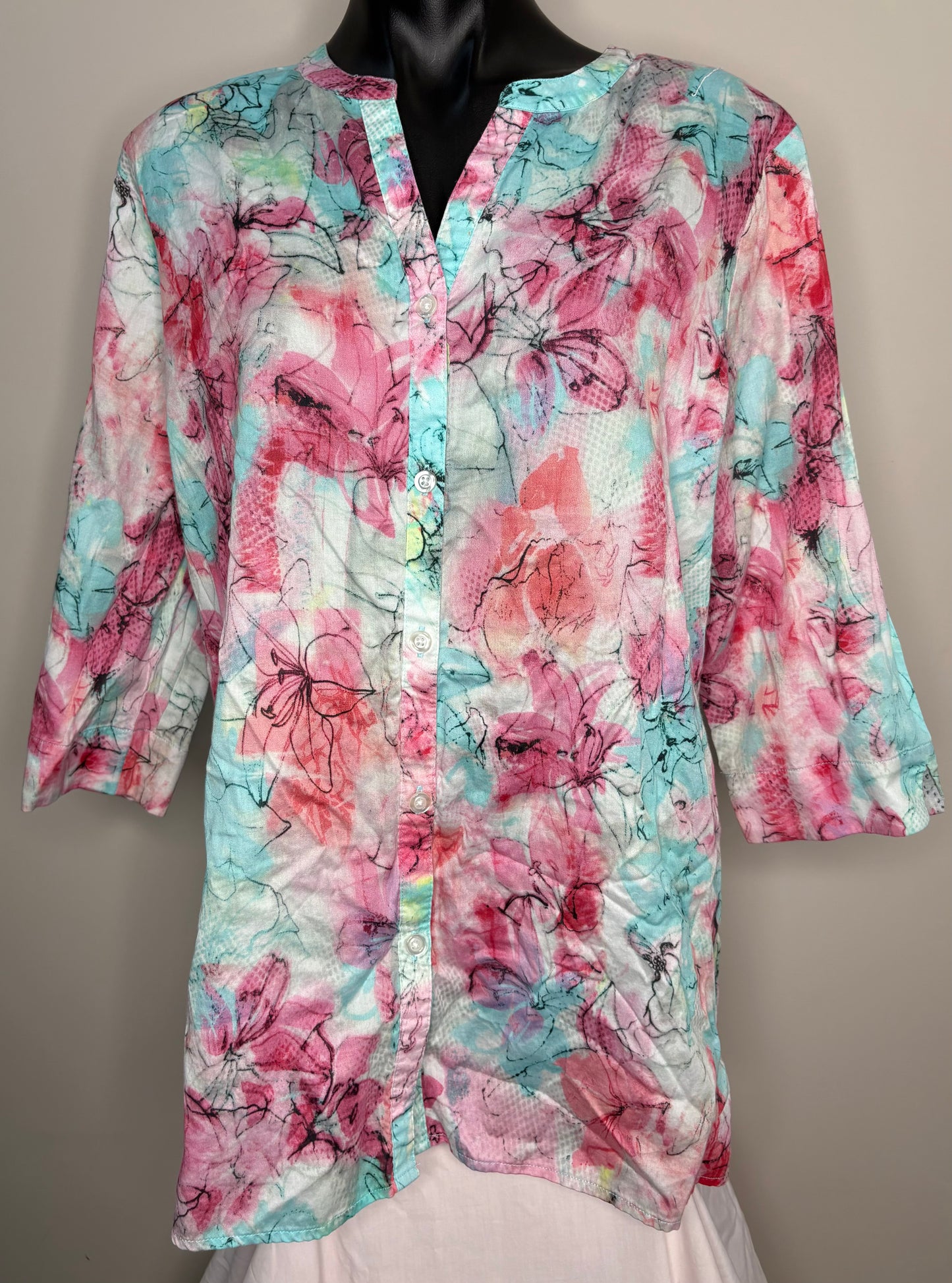 Floral patterned shirt on a mannequin against a neutral background
