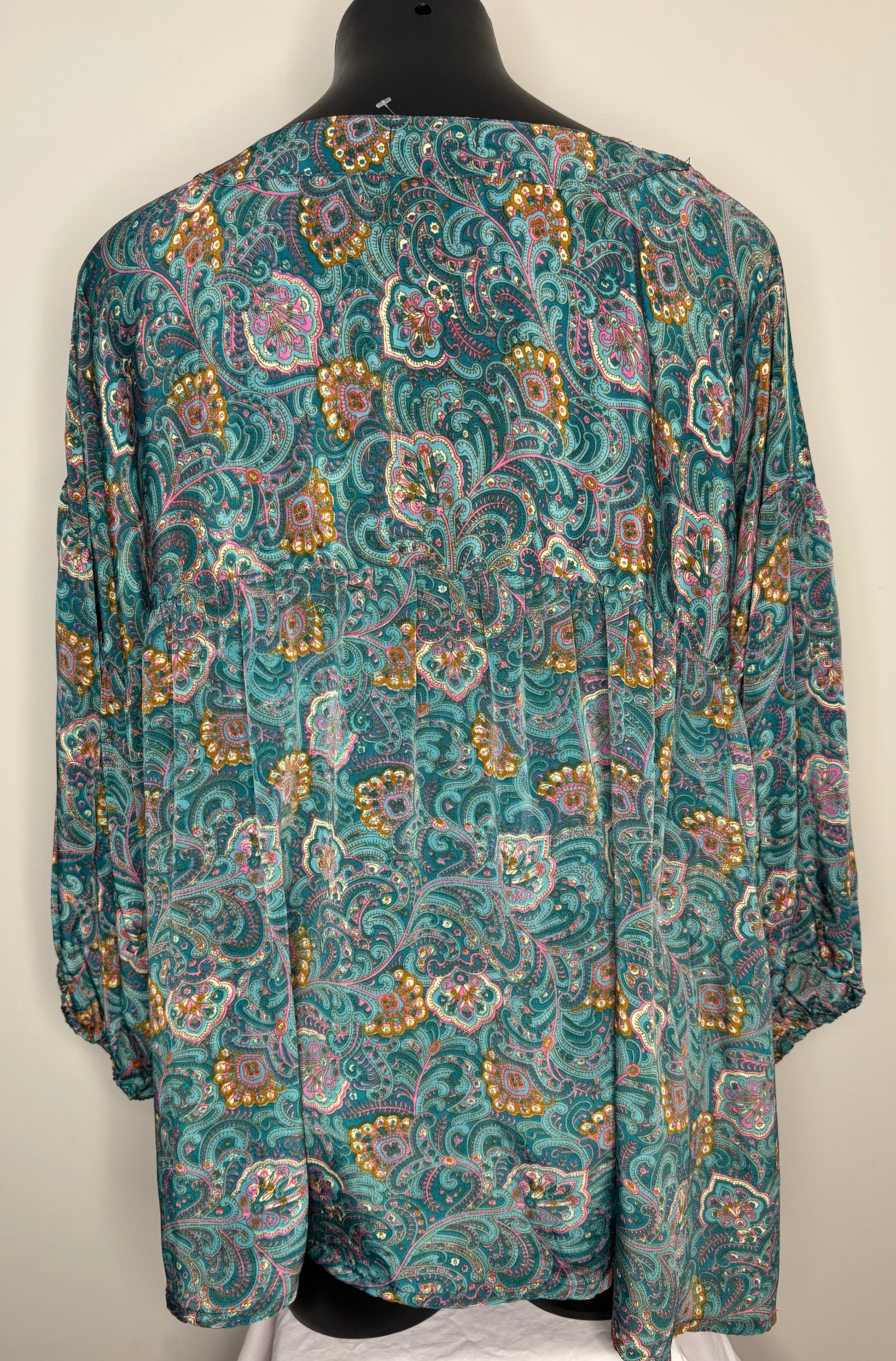 Teal patterned shirt on a mannequin against a plain background