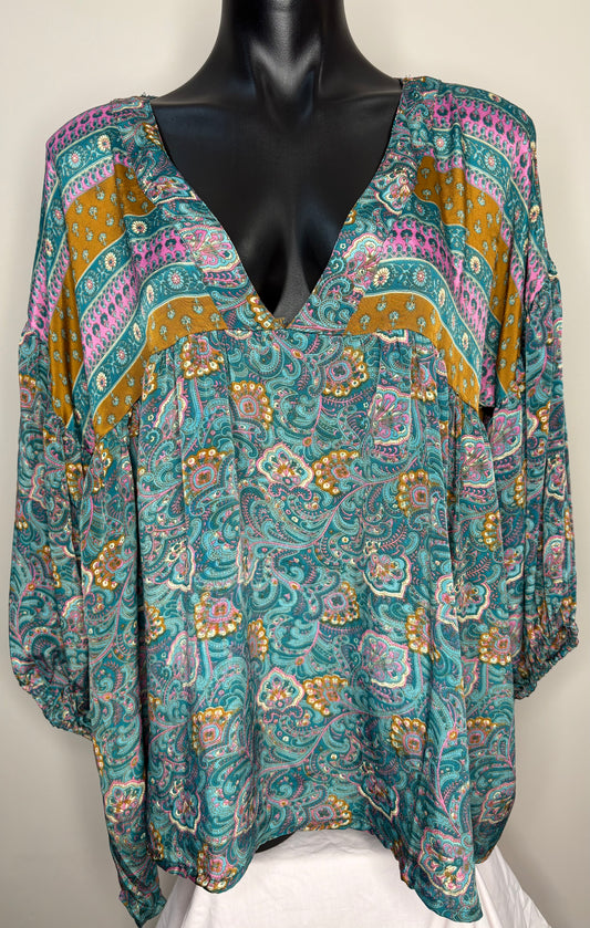 Colorful patterned blouse on a mannequin against a white background