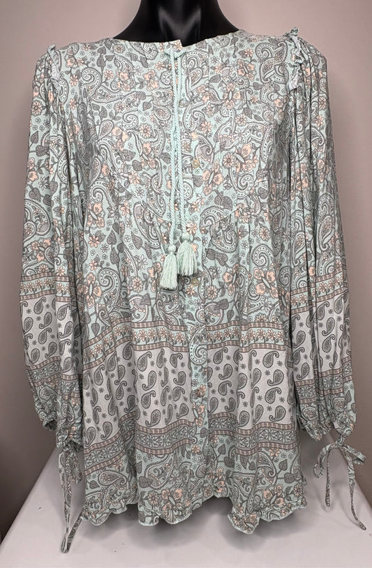 Long-sleeve patterned blouse on a mannequin against a neutral background