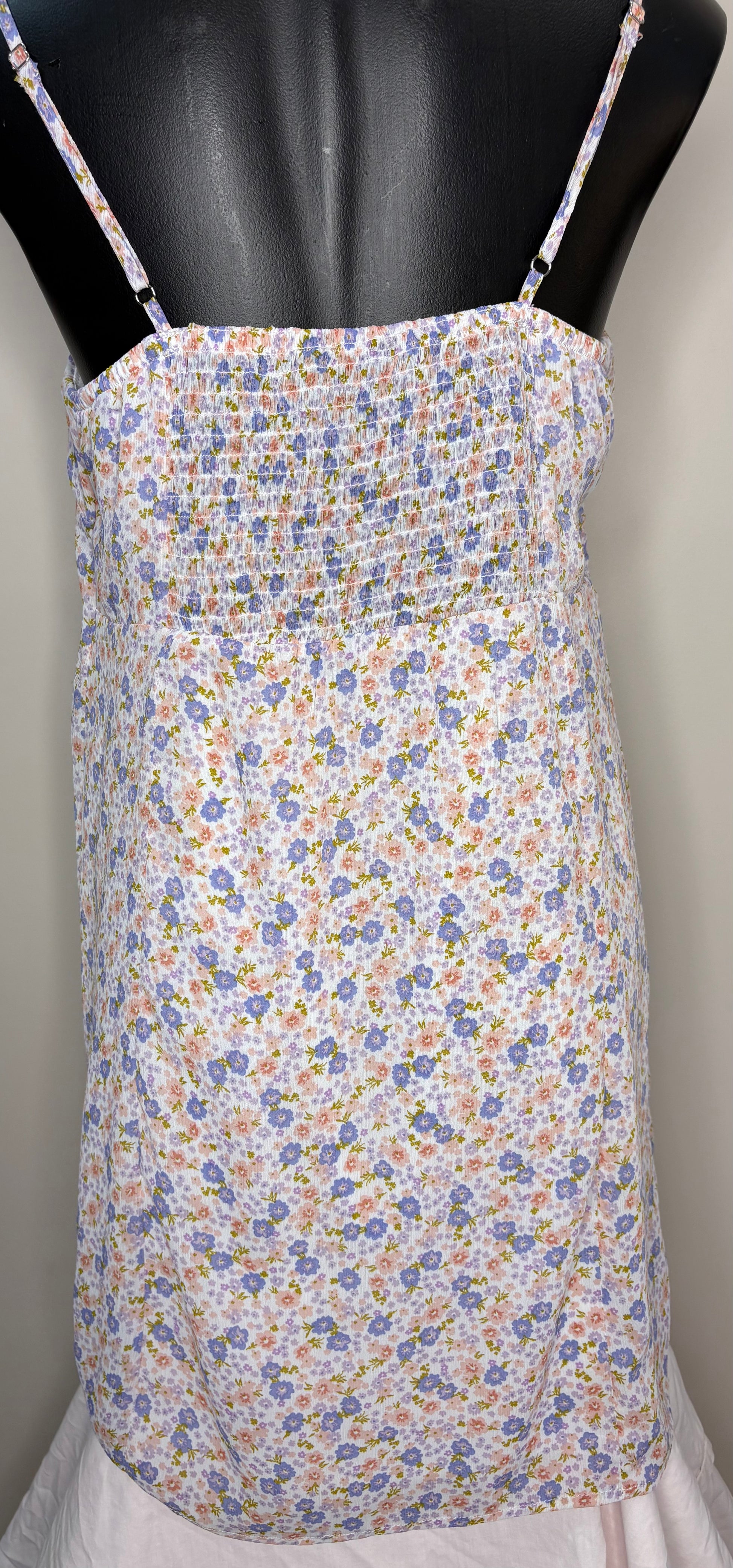 Floral-patterned dress on a mannequin against a plain background
