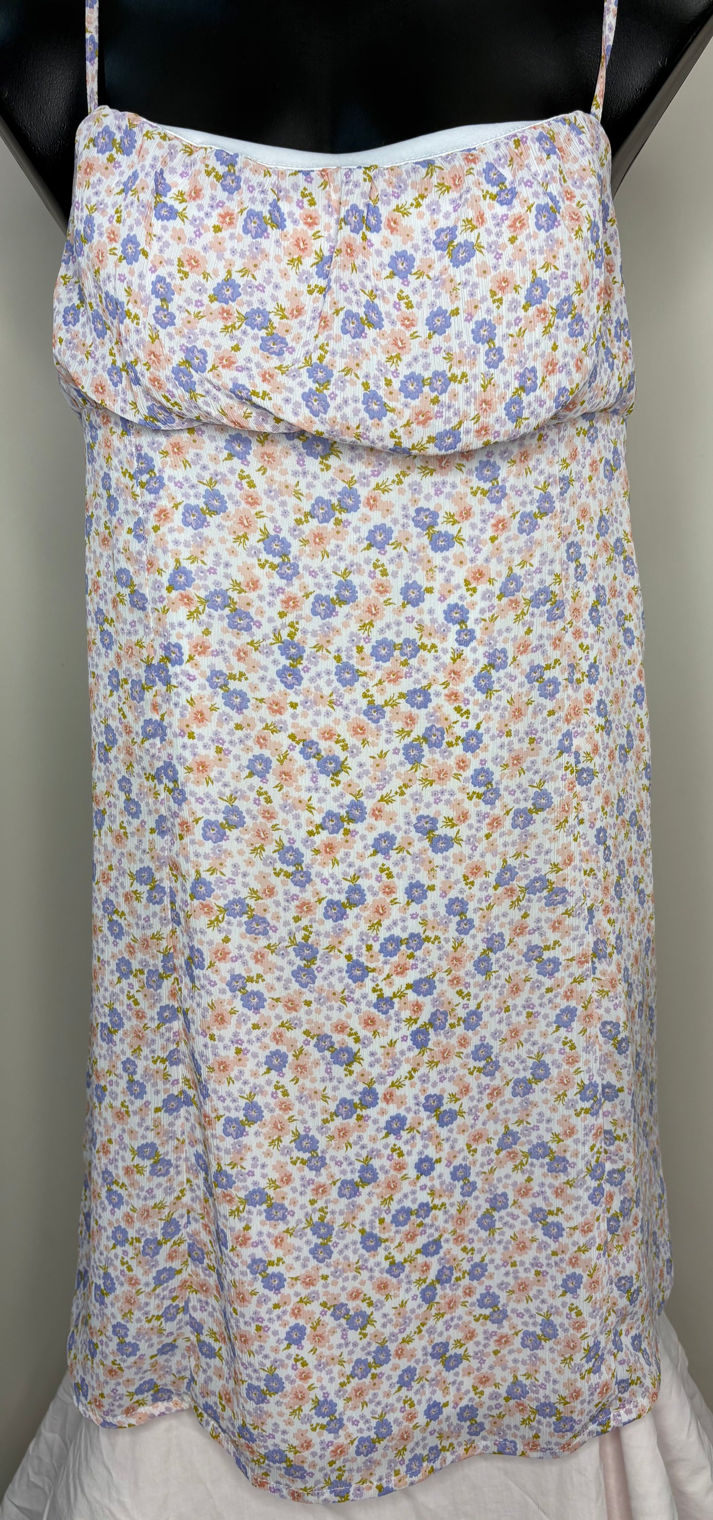 Floral-patterned apron on a mannequin against a neutral background