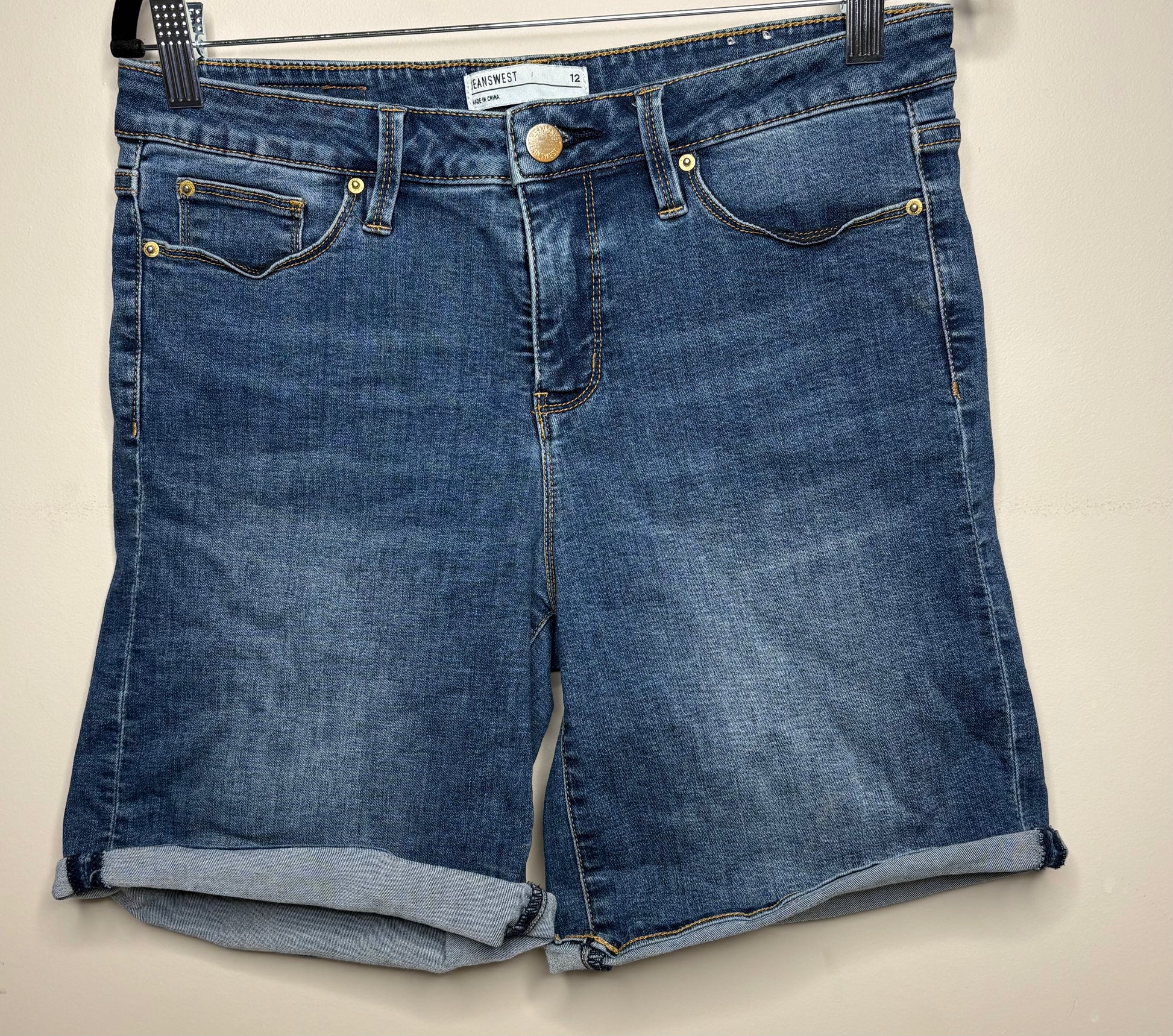 Pair of blue denim shorts on a beige background