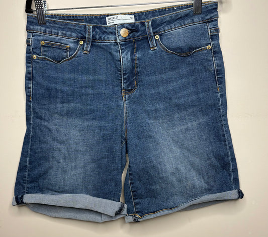 Pair of blue denim shorts on a beige background