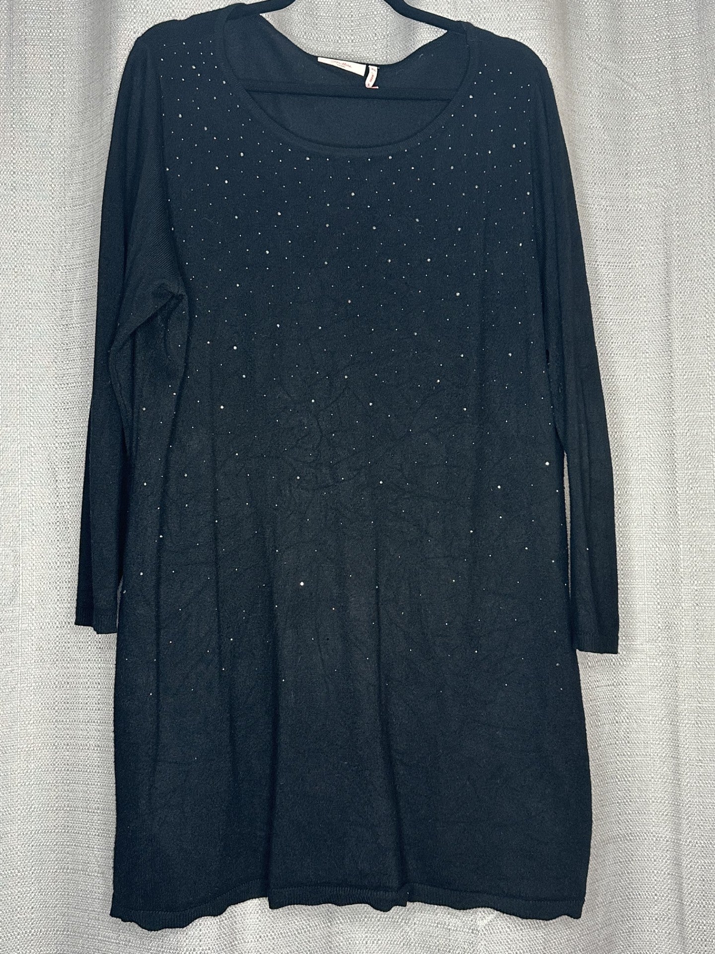 Black dress with small white embellishments on a light gray background