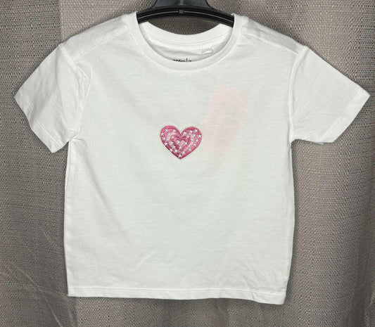White t-shirt with a pink heart design on a gray background
