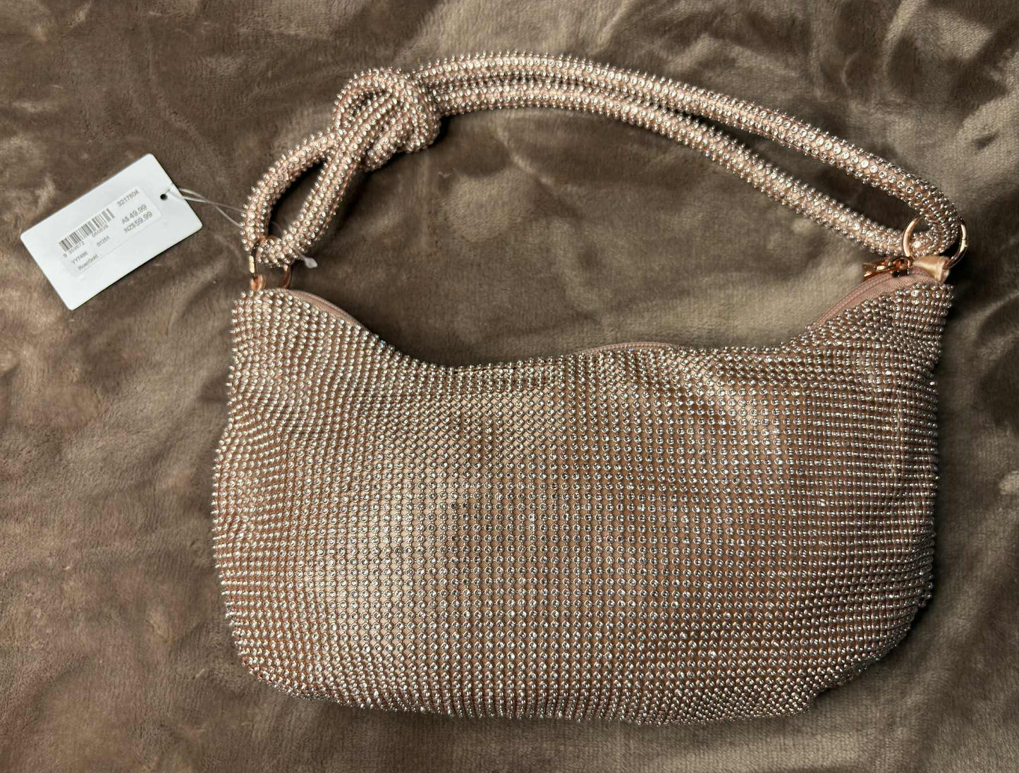 Metallic handbag with a tag on a brown surface