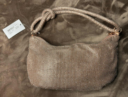Metallic handbag with a tag on a brown surface
