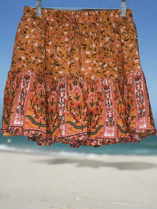 Floral patterned skirt with ruffled hem on a beach background