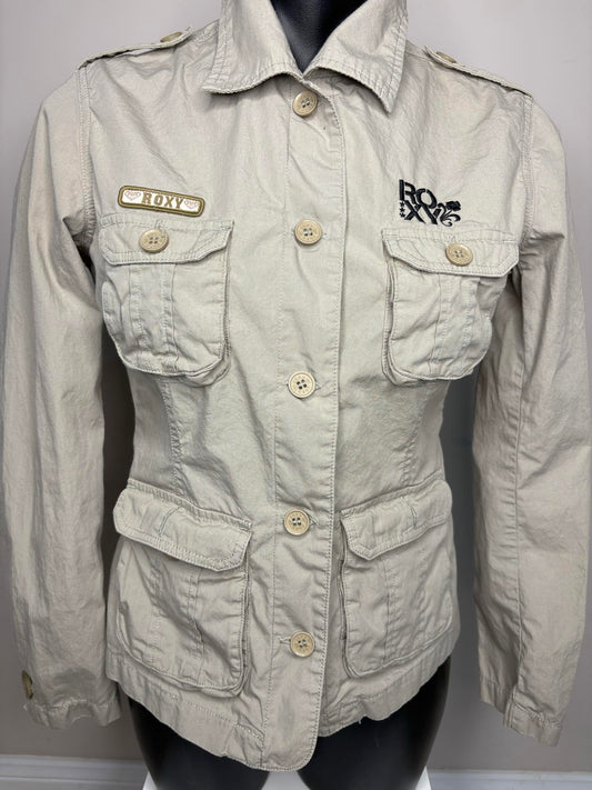 Light beige jacket with brand logos on a mannequin against a gray background