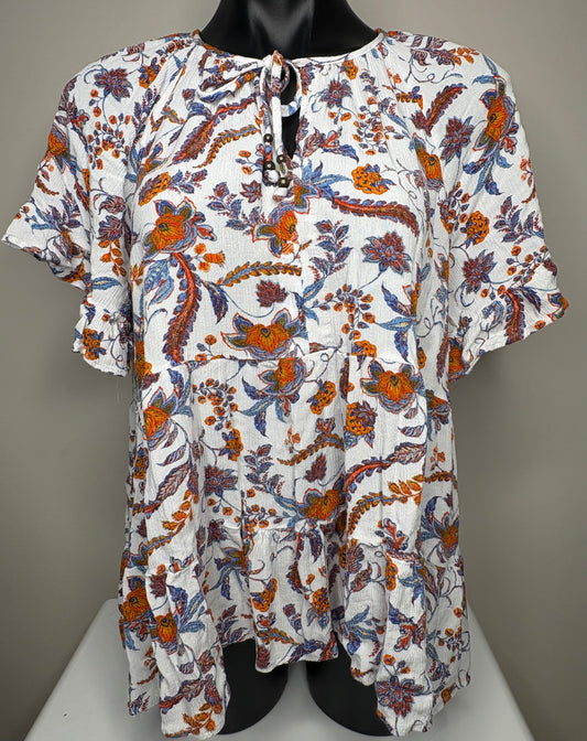Floral patterned top on a mannequin against a gray background