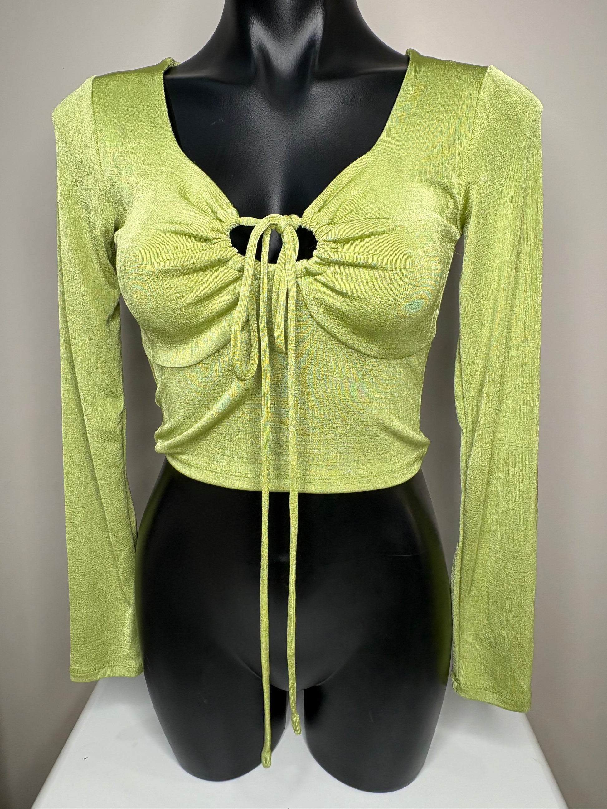 Green long-sleeve top with a bow detail on a mannequin against a neutral background