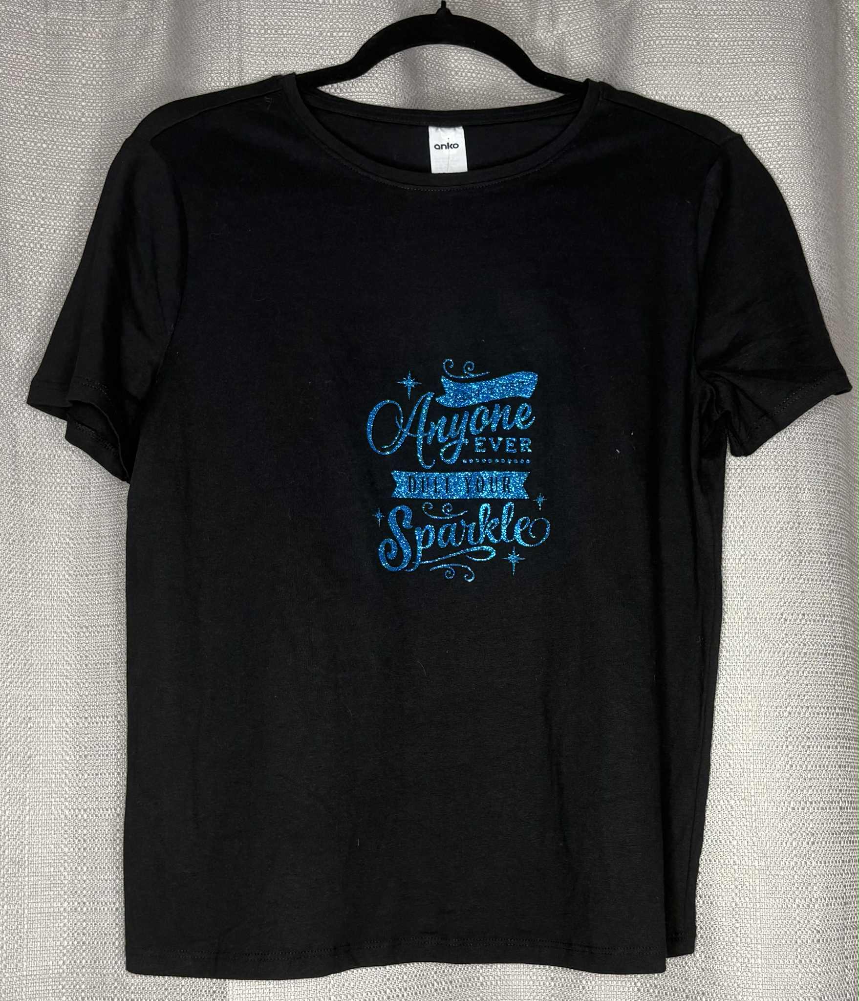Black t-shirt with blue text on a gray background