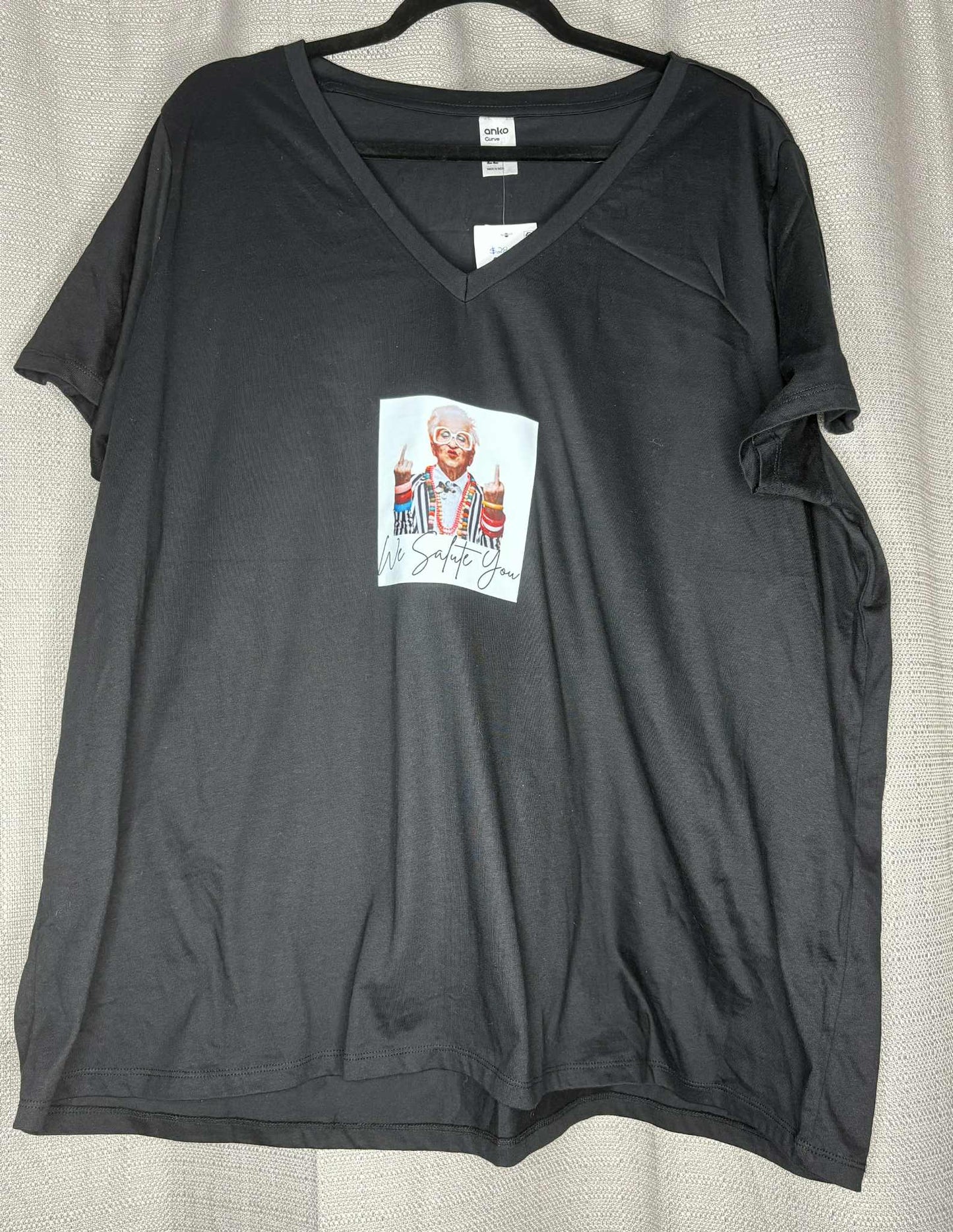 Black t-shirt with a colorful graphic on a beige background