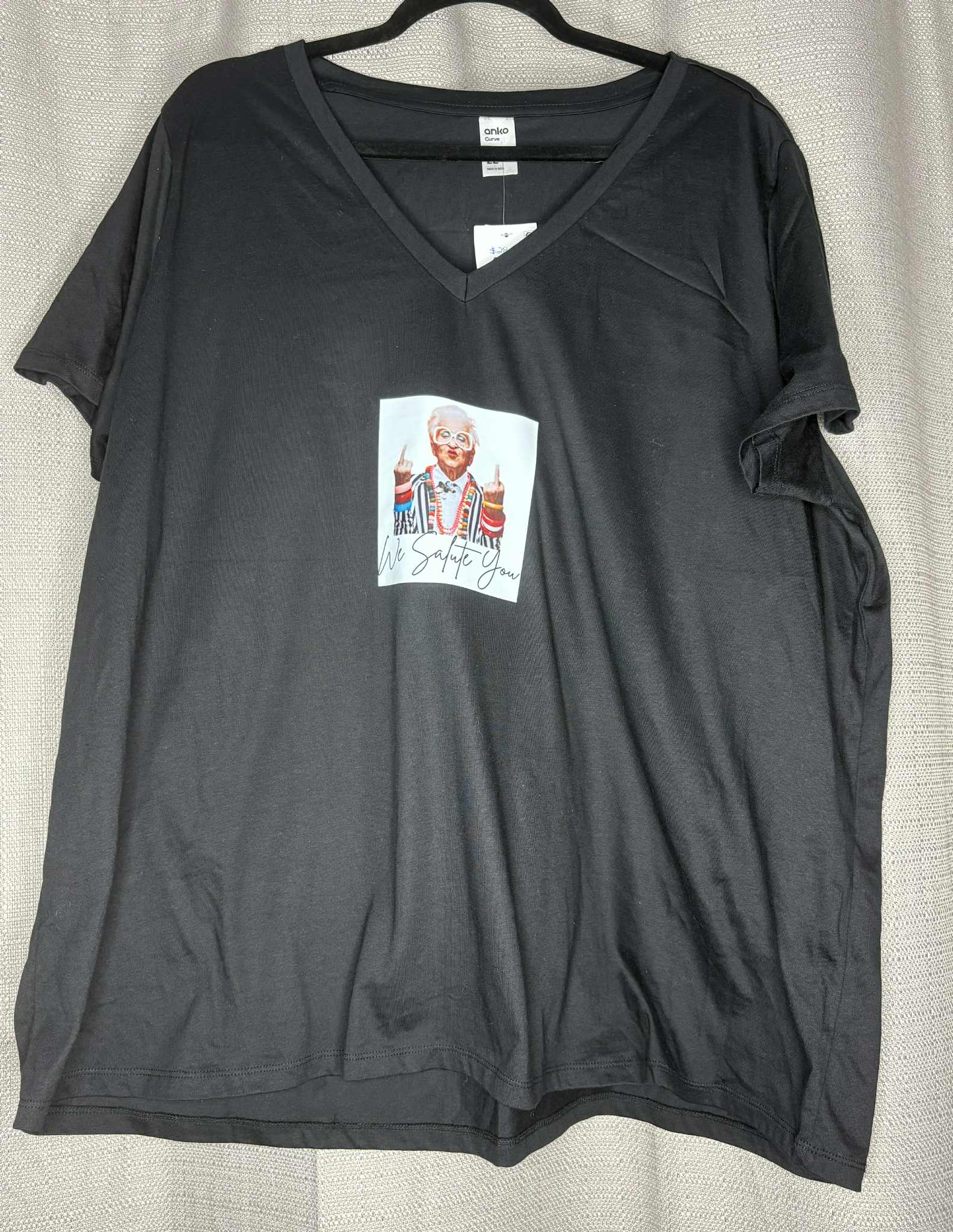 Black t-shirt with a colorful graphic on a beige background