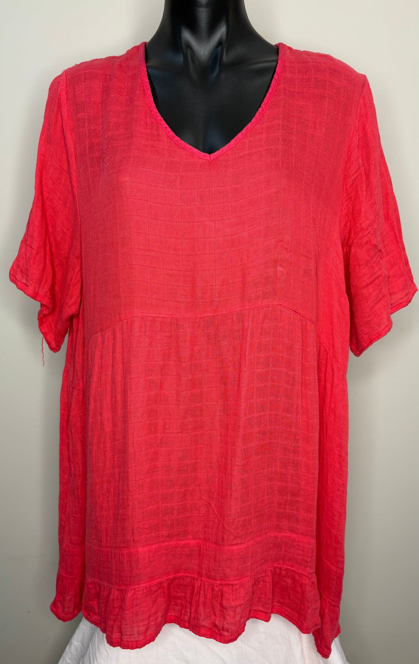 Red textured blouse on a mannequin against a plain background