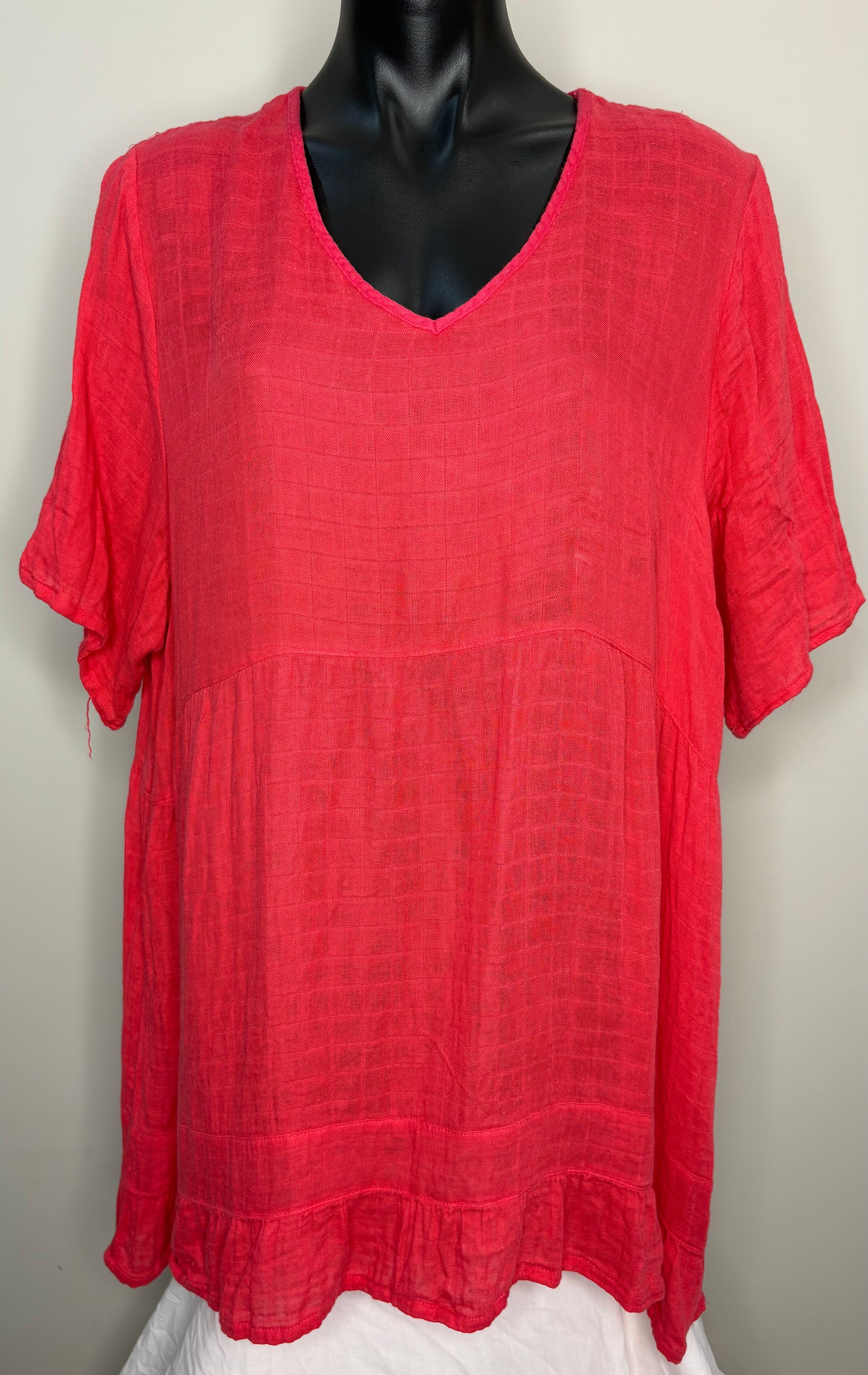 Red textured blouse on a mannequin against a plain background