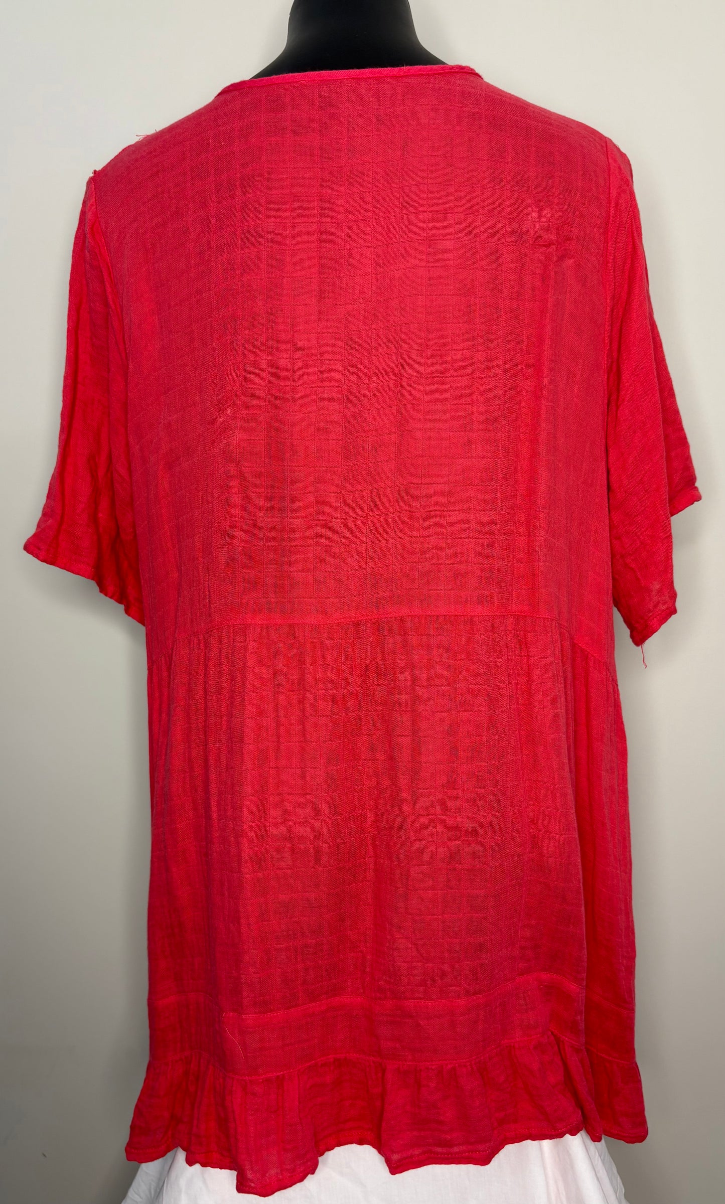 Red textured blouse on a mannequin against a plain background