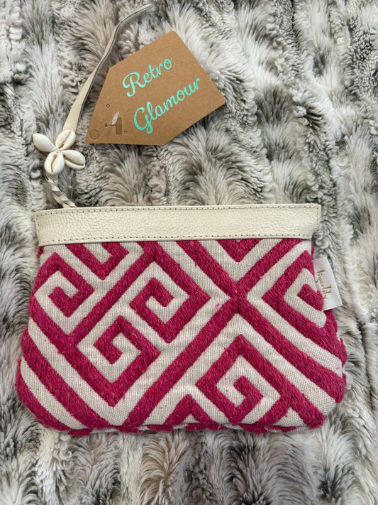 Pink and white patterned pouch on a textured surface