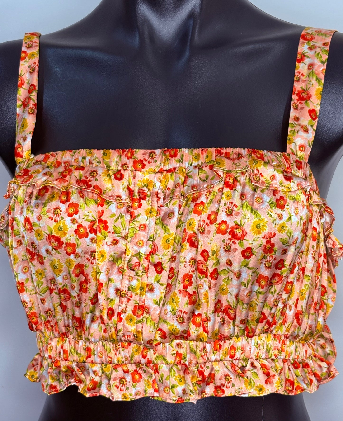 Floral patterned top on a mannequin against a plain background