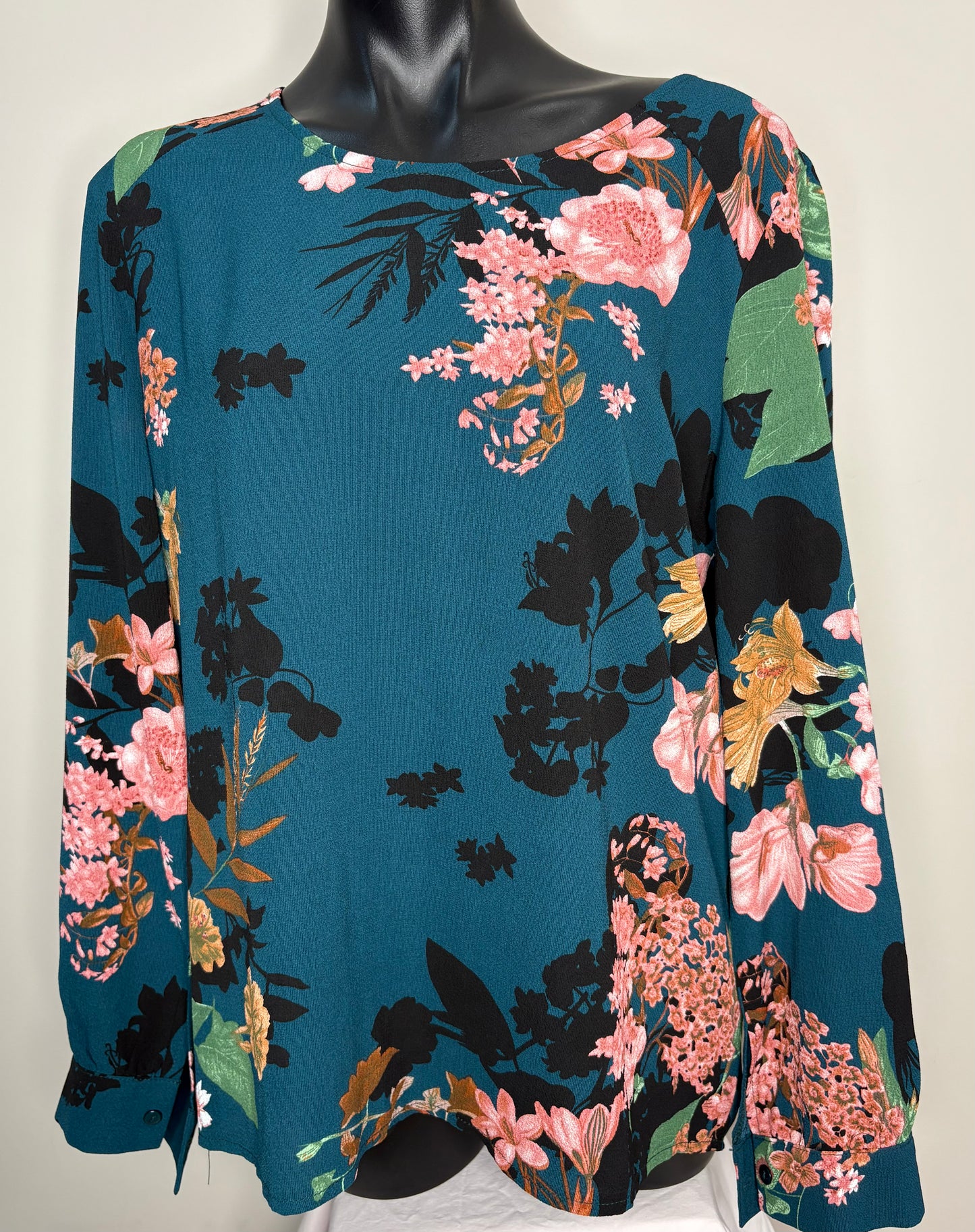 Floral patterned top on a mannequin against a white background