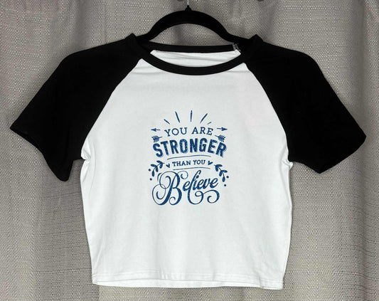 White baseball shirt with black sleeves and motivational quote on a hanger
